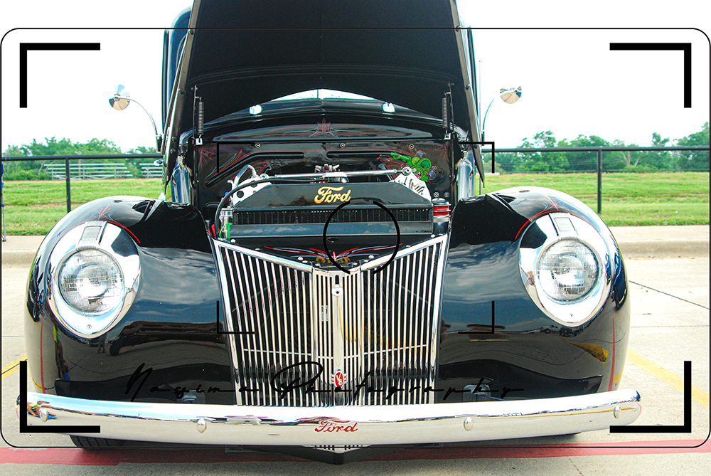 black oldtimer with open hood and red/green painting on the engine in Burlington, Texas