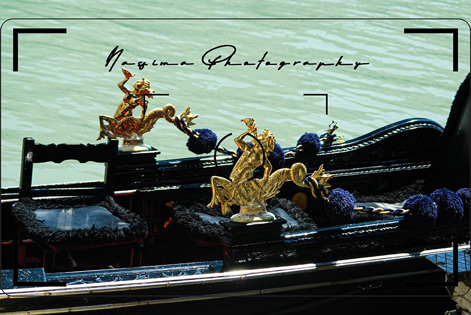 Detail einer reich verzierten schwarzen Gondel mit goldenen Figuren auf einem Kanal in Venedig.